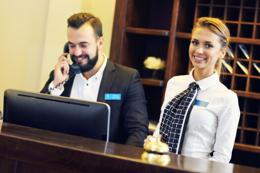 Man and worman at hotel front desk.