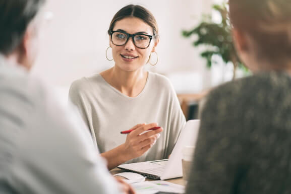 Female meeting with another female and male in a business setting.